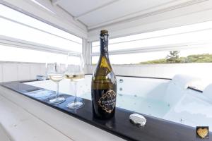una bottiglia di vino su un tavolo con due bicchieri di SuiteFrattini Private Spa Rooftop a Roma