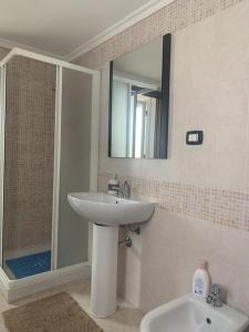 un bagno con lavandino e doccia con specchio di Casa Adriana, centralissima, confinante ospedale civile a Sassari