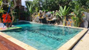 a swimming pool with a waterfall in a resort at Dewi Sri Guesthouse in Mataram