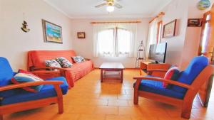 - un salon avec des fauteuils bleus et un canapé dans l'établissement VACAY Villa Carmen, ideal para desconectar, muy tranquilo!, à L'Escala