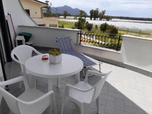 einen weißen Tisch und Stühle auf dem Balkon in der Unterkunft Appartamento al primo piano MARGHERITA in Sabaudia