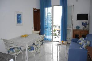 uma sala de estar com uma mesa branca e cadeiras em Sea&sky em Praiano