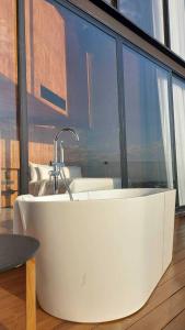 a bath tub in a room with a large window at Livist Resort phetchabun in Phetchabun