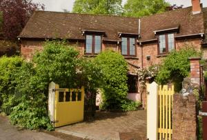 une porte jaune devant une maison en briques dans l'établissement Minehead mews cottage, à Minehead