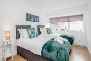 a bedroom with two beds with green cushions at 2 Bedroom Apartment At Modernview Serviced Accommodation Watford Town Centre F15 in Watford