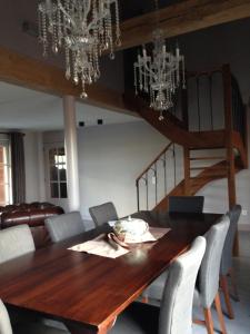 a dining room with a wooden table and chandeliers at B&B Droomzoet in Herentals