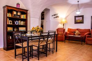 ein Wohnzimmer mit einem Tisch, Stühlen und einem Sofa in der Unterkunft Casa Rural Los Gaitanes in Valverde de Leganés