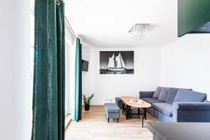 a living room with a blue couch and a table at Apartament Zielony OPTILOCUS in Gdańsk