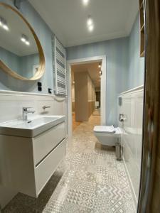 W łazience znajduje się umywalka, toaleta i lustro. w obiekcie APARTAMENT MORSKI KRYNICA MORSKA w mieście Krynica Morska