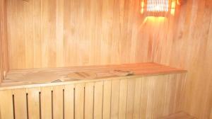 a sauna with a wooden wall and a shelf at Baza Otdiha Zamok in Khmelëvka