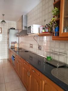 uma cozinha com armários de madeira e um balcão preto em laurainu em Puerto del Rosario