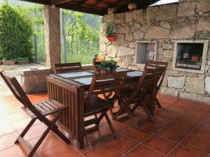 a wooden table and chairs on a patio at Casa Martagão do Gerês by Gerês Casas in Caniçada