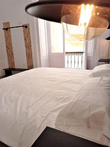 a bed in a room with a lamp on top of it at Planeta Cadiz Hostel in Cádiz