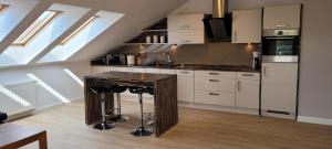 a kitchen with a wooden island in a room with skylights at Apartament 44 in Grzybowo