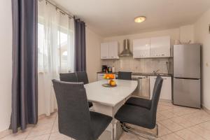 a kitchen with a white table with chairs and a refrigerator at Villa Sali in Sali