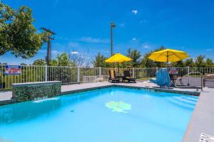 - une piscine avec deux parasols jaunes dans l'établissement Studio Z, Ascend Hotel Collection, à St. Robert