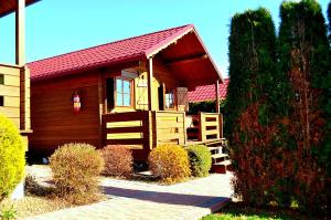 a small house with a red roof and a porch at Domki Olina in Polańczyk