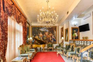 sala de estar con piano de cola y lámpara de araña en Premier Prezident Garni Hotel and Spa en Sremski Karlovci