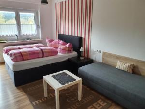 ein Schlafzimmer mit zwei Betten und einem Tisch und einem Fenster in der Unterkunft Aventur Studio 212 Am Rotharrsteig in Medebach