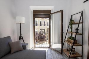 een woonkamer met een bank en een spiegel bij Elegante Apartamento para 5 en el centro de Cáceres con wifi in Cáceres
