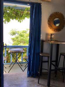 a door to a balcony with a blue curtain at Chez Cécile Home in Mochlos +95 photos