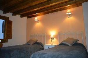 2 camas en una habitación con luces en la pared en La Casa de Villar, en Villar de Torre