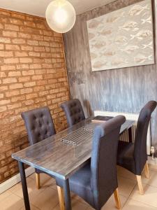 基德明斯特的住宿－Stunning Stylish & Spacious Ground Floor Apartment, Kidderminster，一间带木桌和椅子的用餐室