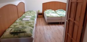 2 camas en una habitación con puerta abierta en Borgaléria en Tokaj