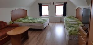 um quarto com duas camas, uma mesa e um sofá em Borgaléria em Tokaj