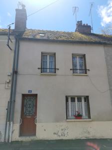 Châtillon-Coligny的住宿－La Gâtinaise，白色的房子,设有两扇窗户和一扇门