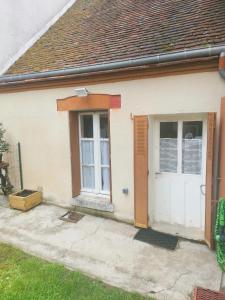 uma casa branca com uma porta branca e janelas em La Gâtinaise em Châtillon-Coligny