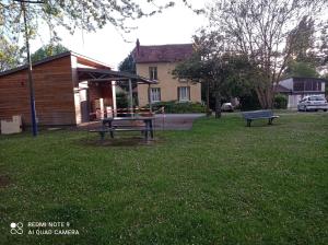 einem Park mit Picknicktisch und einem Gebäude in der Unterkunft Au calme, devant le port, studio indépendant in Lere