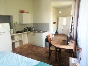 Zimmer mit einer Küche und einem Tisch sowie einem Zimmer mit einem Bett in der Unterkunft Au calme, devant le port, studio indépendant in Lere
