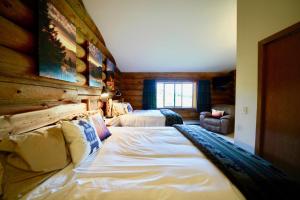 1 dormitorio con 2 camas y pared de madera en Flat Fish Lodge B&B and Event Center en Homer