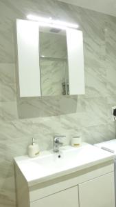 a white bathroom with a sink and a mirror at Saroko Residence in Corfu Town +14 photos