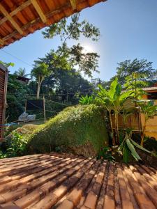 a view of a garden with a wooden deck at Pousada Familia Viva Trindade in Trindade