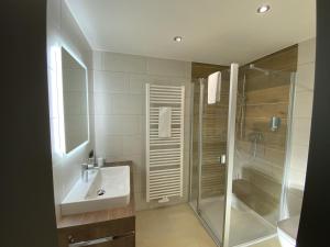 bagno bianco con lavandino e doccia di Hotelgasthof Kirchenwirt a Schierling