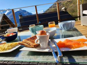 una mesa con desayuno de tostadas, huevos y fruta en superbe grange rénovée, en Grust