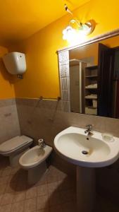 bagno con lavandino, servizi igienici e specchio di Casa Beatrice a Bolsena