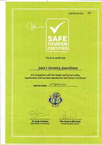 a green envelope with a safe tourism certified certificate at Janes' Serenity Guesthouse in Anse a La Mouche