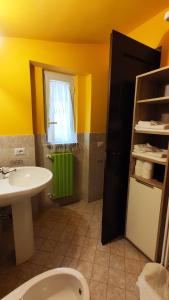 łazienka z umywalką, toaletą i oknem w obiekcie Casa Beatrice w mieście Bolsena