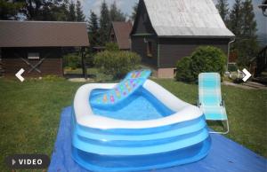 a blue and white inflatable pool in a yard at Nabízím chatu na pronájem in Komňa