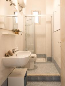 a white bathroom with a sink and a toilet at VENTO DI SCIROCCO CASA VACANZE A POCHI METRI DAL MARE in Santa Flavia