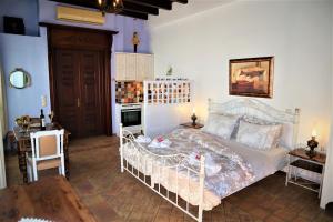 a bedroom with a white bed and a fireplace at Saint George Valsamitis Superior in Katapola