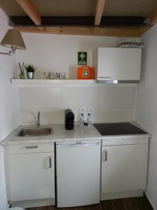una cucina con mobili bianchi e un lavandino di Guest House Páteo da Cadeia Velha a Serpa Altre 36 foto