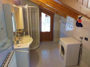 a bathroom with a sink and a washing machine at Casa Al Noce Mastellina Apt. Solandra in Commezzadura