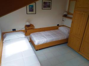 duas camas individuais num quarto com duas portas em Casa Al Noce Mastellina Apt. Solandra em Commezzadura