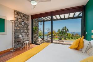 ein Schlafzimmer mit einem großen Bett und einem großen Fenster in der Unterkunft OurMadeira - Garden Paradise, stunning in Calheta + 24 Fotos