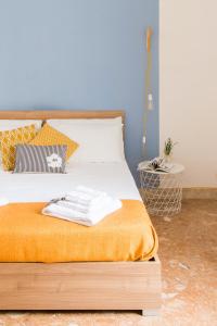 1 dormitorio con 1 cama con manta naranja en VENTO DI SCIROCCO CASA VACANZE A POCHI METRI DAL MARE, en Santa Flavia