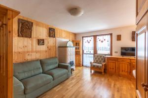 ein Wohnzimmer mit einem Sofa und einer Küche in der Unterkunft Casa Piz Meda in Soraga